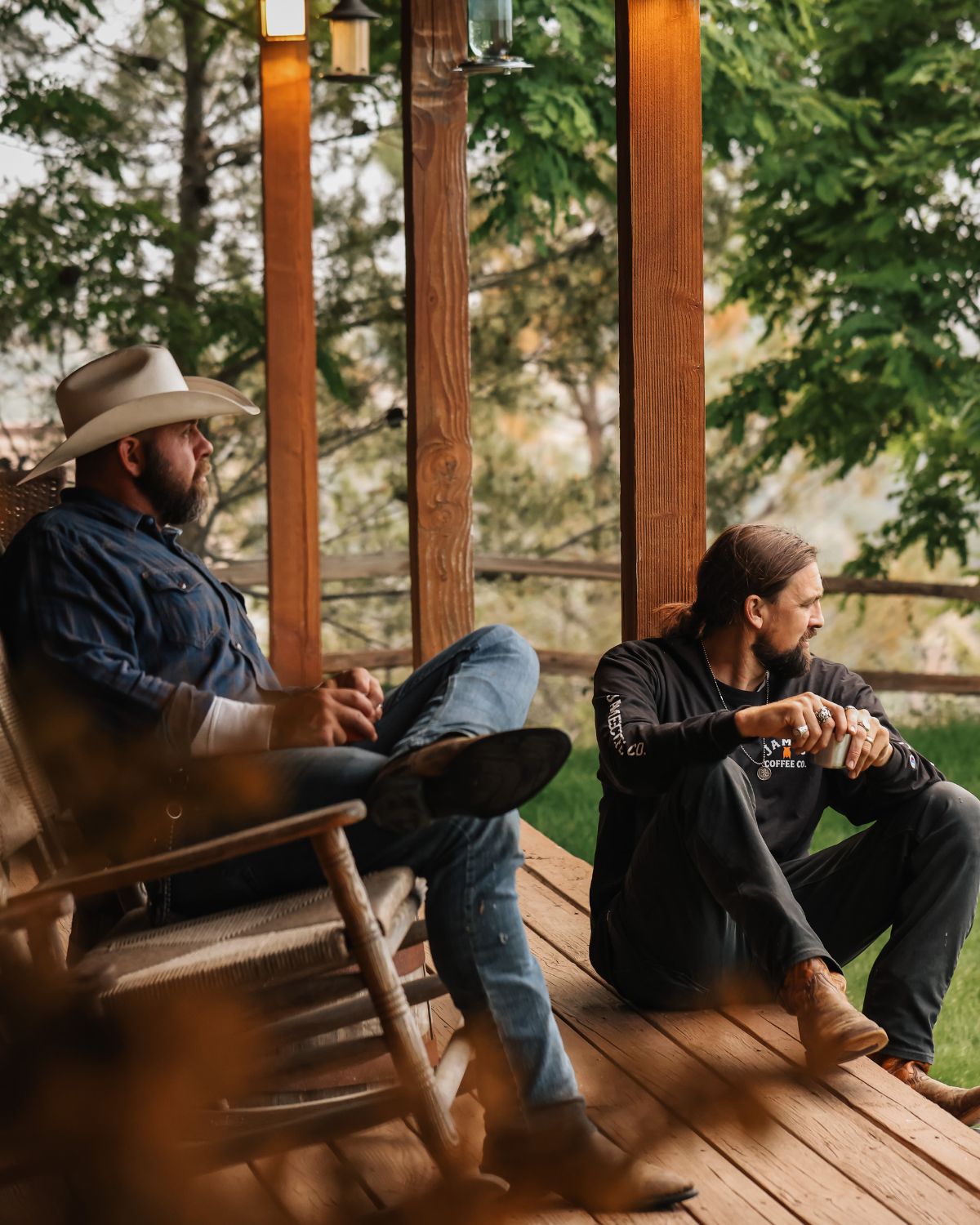 David and Jacob Kennedy sitting on a porch enjoying coffee